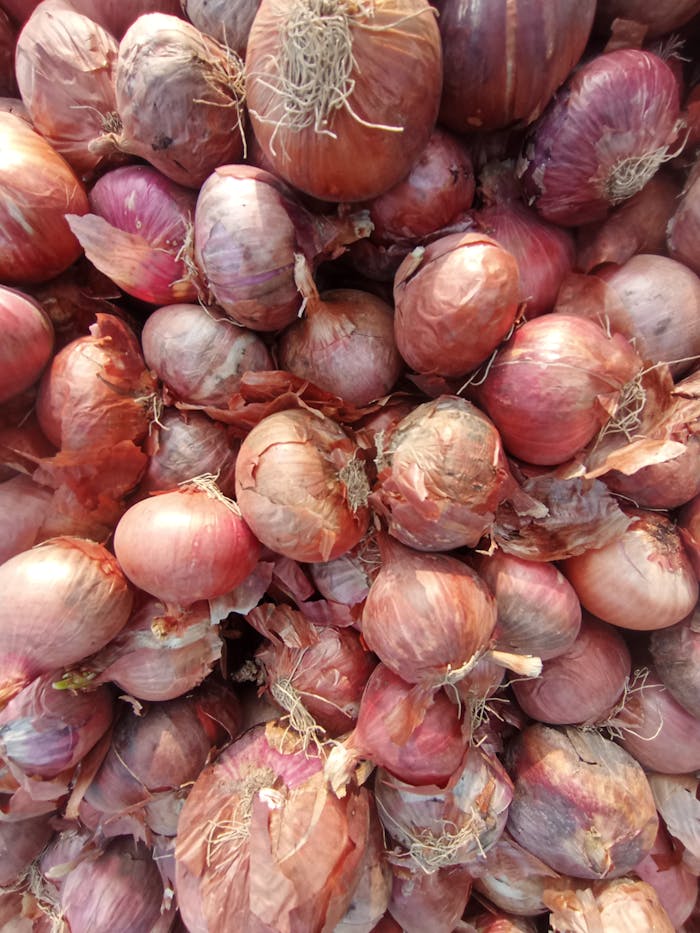 A vibrant close-up of fresh red onions piled together, showcasing their natural textures.